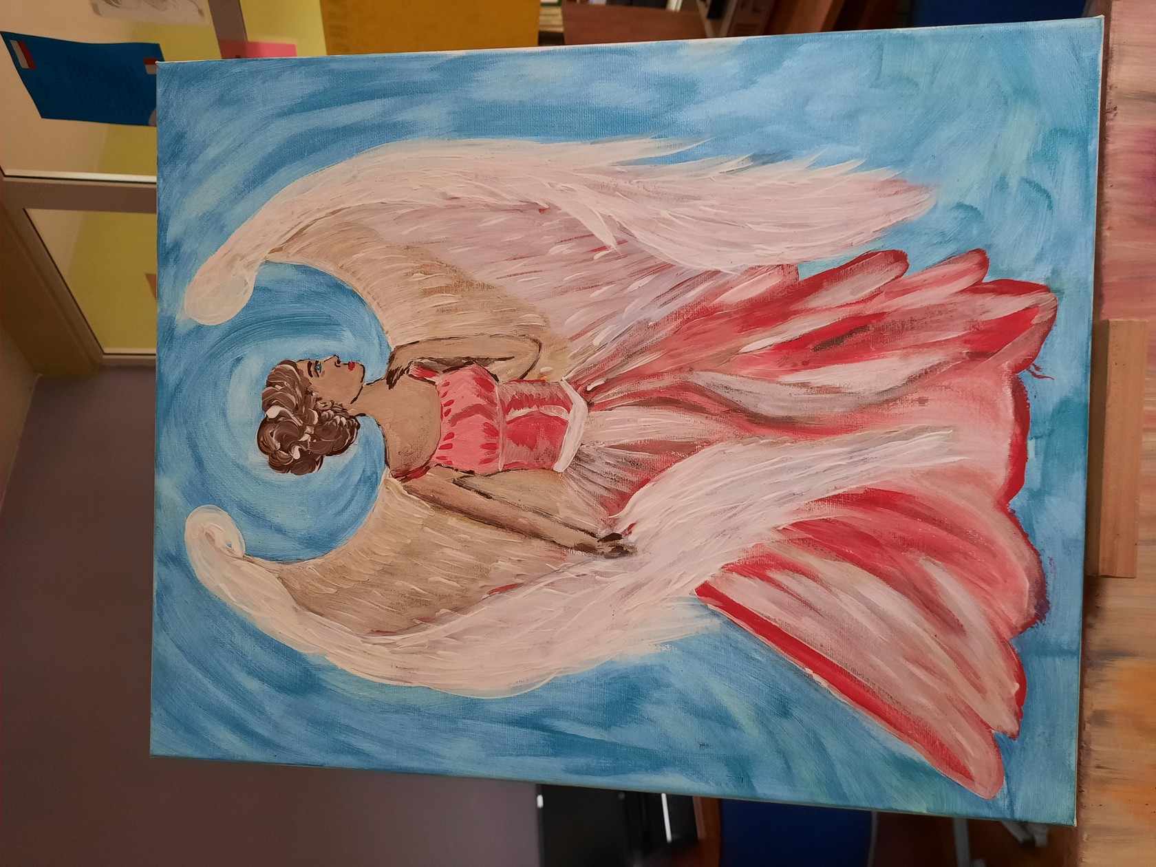 Obraz-Kobieta ze skrzydłami anioła na niebieskim tle.